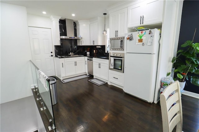 2725 N 20th St, Kansas City, KS 66104 - kitchen featuring appliances with stainless steel finishes, wall chimney exhaust hood, tasteful backsplash, white cabinets, and recessed lighting