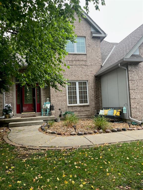 15733 Pine Cir, Basehor, KS 66007 - view of front of home with brick siding, a shingled roof, and a front yard