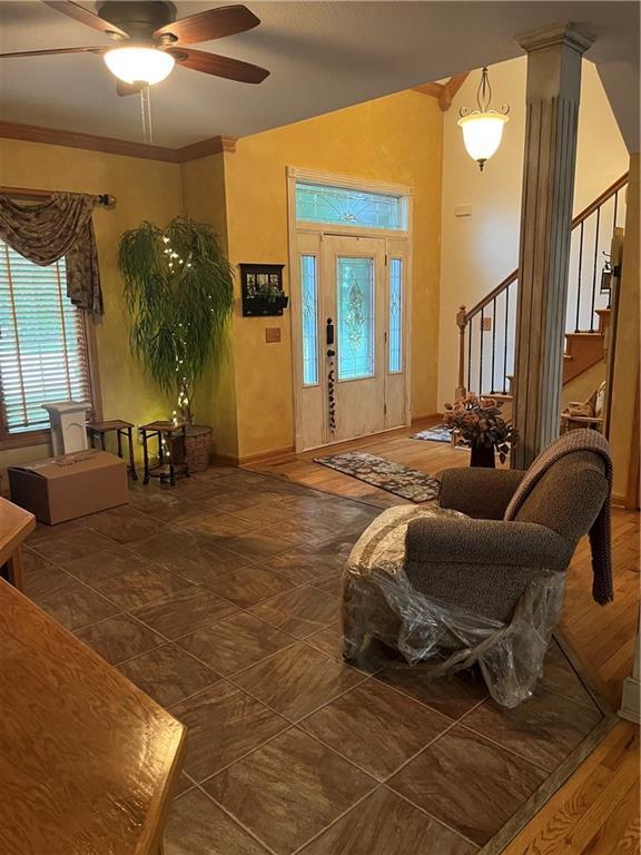 15733 Pine Cir, Basehor, KS 66007 - entrance foyer with stairway, a ceiling fan, and crown molding