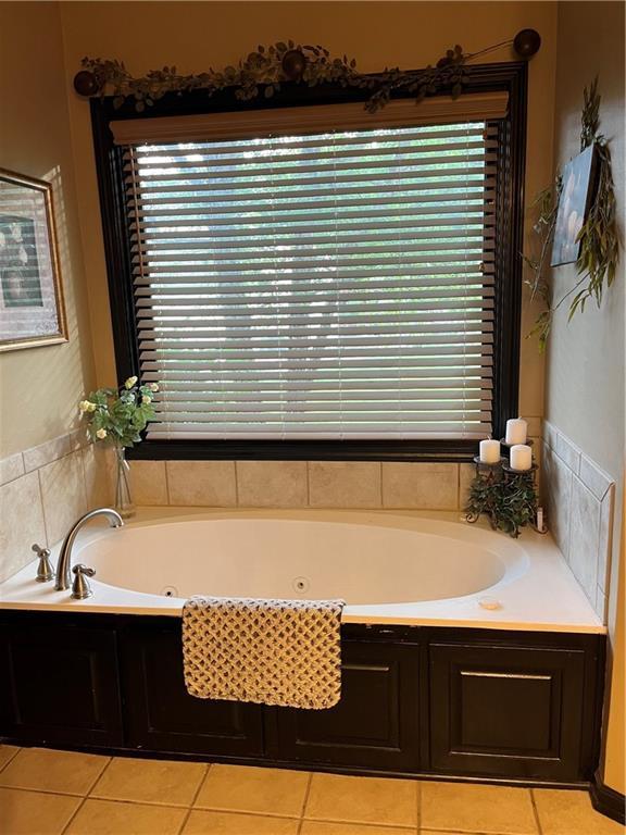 15733 Pine Cir, Basehor, KS 66007 - bathroom featuring a jetted tub and tile patterned flooring
