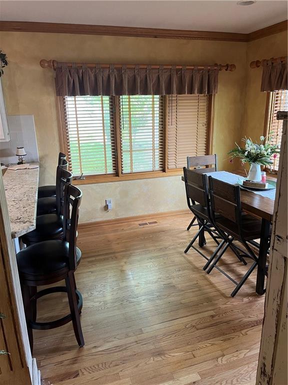 15733 Pine Cir, Basehor, KS 66007 - dining space featuring light wood-style flooring and ornamental molding