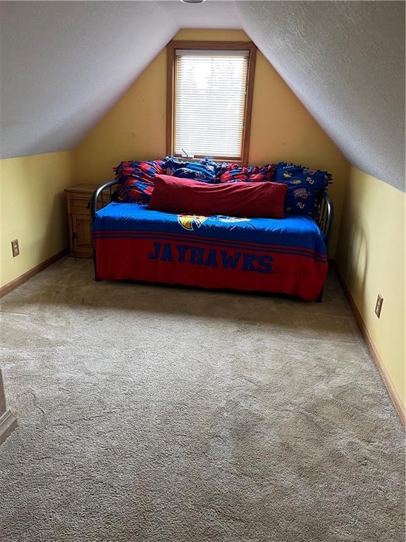 15733 Pine Cir, Basehor, KS 66007 - bedroom with light colored carpet, lofted ceiling, and a textured ceiling