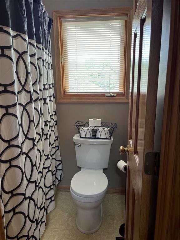 15733 Pine Cir, Basehor, KS 66007 - bathroom featuring tile patterned floors and a shower with shower curtain