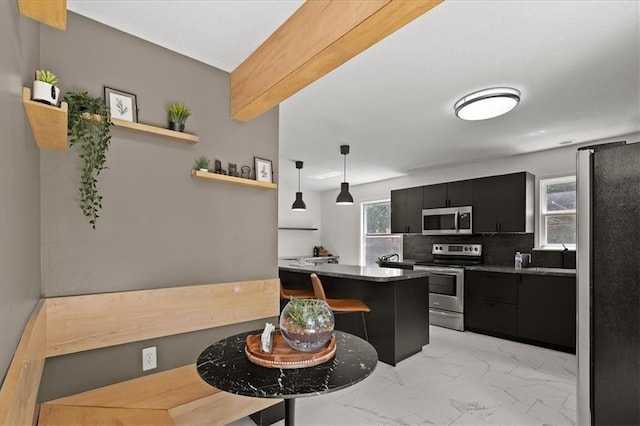 9410 Taylor Dr, Overland Park, KS 66212 - kitchen with stainless steel appliances, dark cabinets, light marble finish floors, tasteful backsplash, and a kitchen breakfast bar
