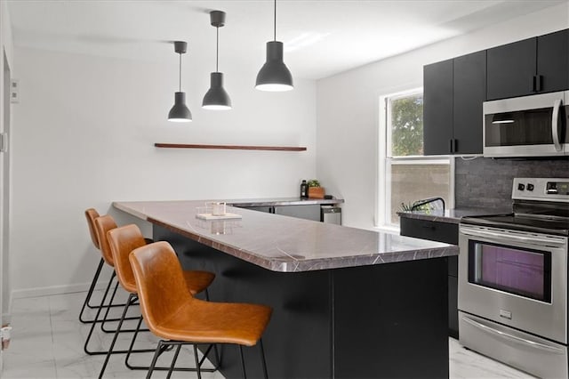 9410 Taylor Dr, Overland Park, KS 66212 - kitchen with appliances with stainless steel finishes, light marble finish flooring, dark cabinetry, a kitchen bar, and tasteful backsplash