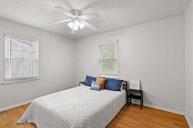 9410 Taylor Dr, Overland Park, KS 66212 - bedroom with multiple windows, wood finished floors, a textured ceiling, and ceiling fan