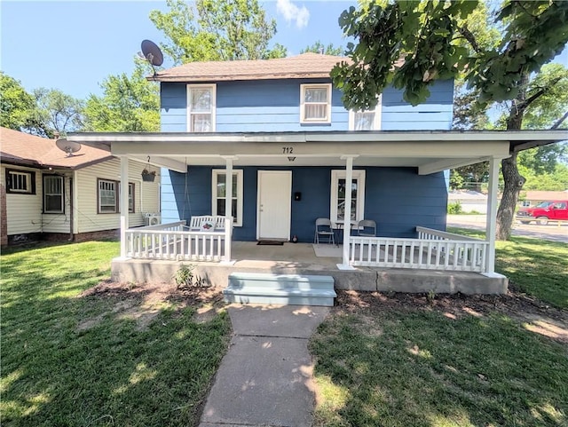 712 N Jefferson Ave, Iola, KS 66749 - view of front of house with covered porch and a front lawn