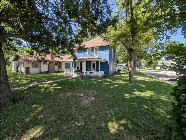 712 N Jefferson Ave, Iola, KS 66749 - view of front of house featuring covered porch and a front yard