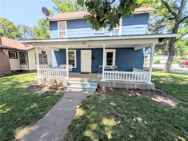 712 N Jefferson Ave, Iola, KS 66749 - traditional style home with a porch and a front lawn