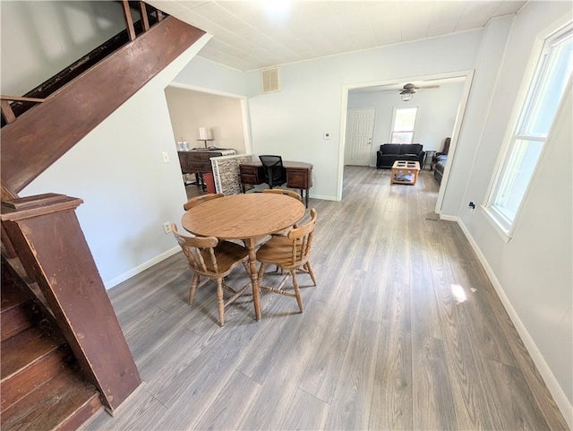 712 N Jefferson Ave, Iola, KS 66749 - dining space with wood finished floors, a ceiling fan, and stairs