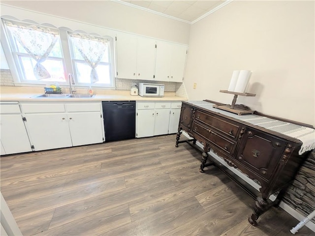 712 N Jefferson Ave, Iola, KS 66749 - kitchen with dishwasher, white microwave, ornamental molding, backsplash, and white cabinets