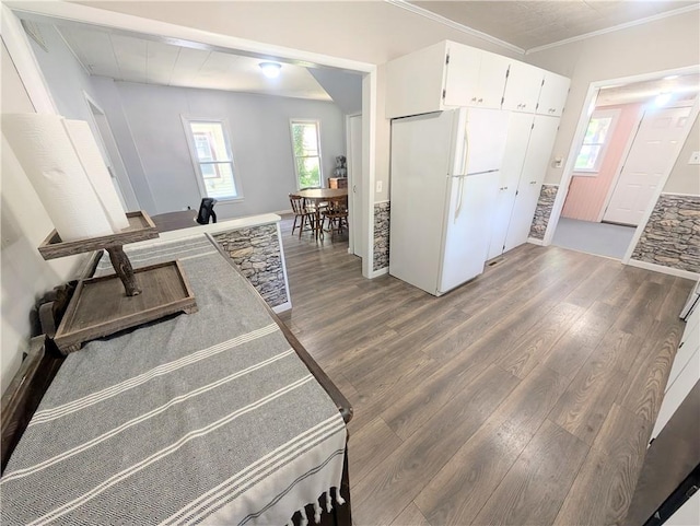 712 N Jefferson Ave, Iola, KS 66749 - kitchen with freestanding refrigerator, wood finished floors, white cabinets, and crown molding