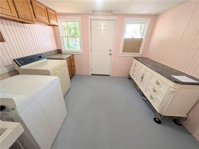 712 N Jefferson Ave, Iola, KS 66749 - laundry room featuring washing machine and dryer, plenty of natural light, and wooden walls