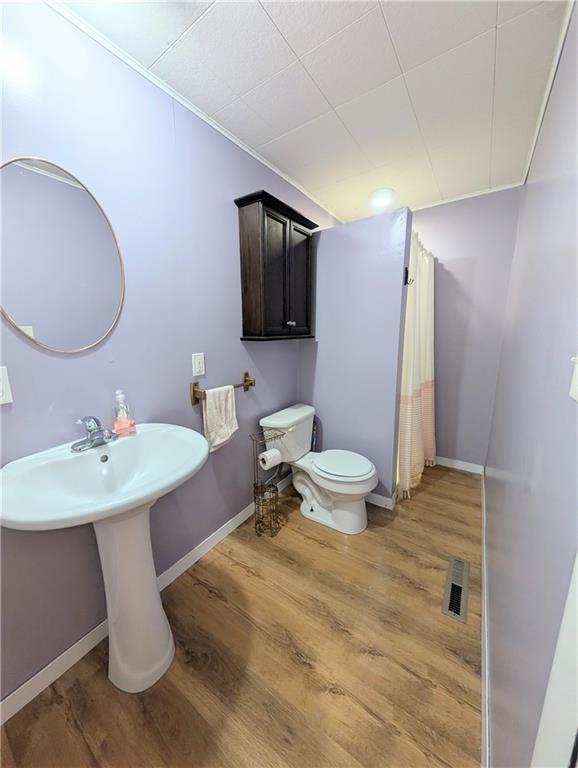 712 N Jefferson Ave, Iola, KS 66749 - full bath featuring wood finished floors and a shower with shower curtain