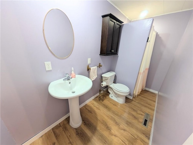 712 N Jefferson Ave, Iola, KS 66749 - bathroom with wood finished floors, curtained shower, and ornamental molding