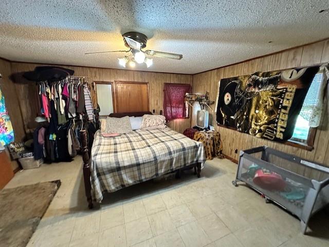 12074 S 1600th Rd, Nevada, MO 64772 - bedroom with wood walls, a ceiling fan, and a textured ceiling