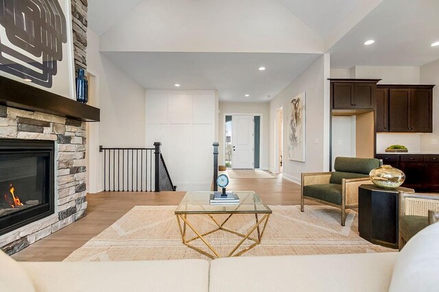 16992 S Cheshire St, Olathe, KS 66062 - living area featuring vaulted ceiling, light wood-style floors, a stone fireplace, and recessed lighting