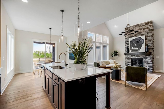 16992 S Cheshire St, Olathe, KS 66062 - kitchen with a chandelier, light wood finished floors, light countertops, open floor plan, and a stone fireplace