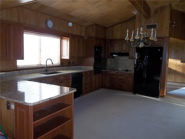 201 S Larson Ave, Chanute, KS 66720 - kitchen with black appliances, a chandelier, under cabinet range hood, open shelves, and wooden walls