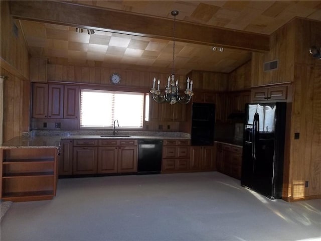 201 S Larson Ave, Chanute, KS 66720 - kitchen featuring black fridge, dishwasher, wooden walls, a chandelier, and decorative light fixtures