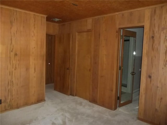 201 S Larson Ave, Chanute, KS 66720 - unfurnished bedroom featuring wooden walls, carpet flooring, and a closet