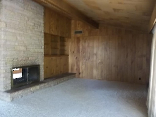 201 S Larson Ave, Chanute, KS 66720 - unfurnished living room featuring carpet floors, wooden walls, and a fireplace
