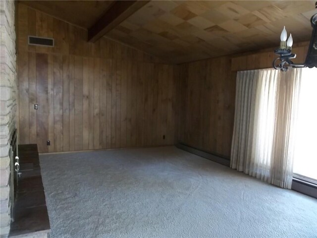 201 S Larson Ave, Chanute, KS 66720 - spare room with light colored carpet, wood walls, and a chandelier