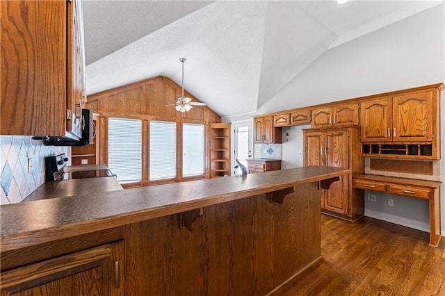 1103 N 2nd St E, Louisburg, KS 66053 - kitchen featuring range, lofted ceiling, brown cabinets, a peninsula, and dark wood-style flooring
