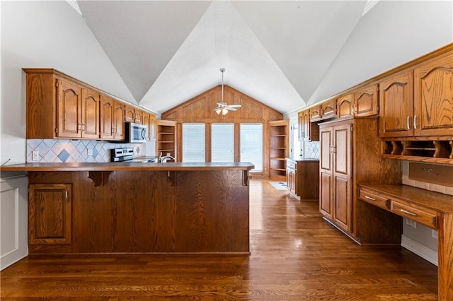 1103 N 2nd St E, Louisburg, KS 66053 - kitchen with vaulted ceiling, a peninsula, stainless steel microwave, brown cabinets, and stove