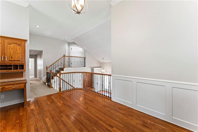 1103 N 2nd St E, Louisburg, KS 66053 - corridor with wood finished floors, an upstairs landing, a chandelier, a decorative wall, and wainscoting
