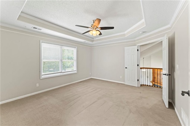 1103 N 2nd St E, Louisburg, KS 66053 - spare room featuring ornamental molding, a raised ceiling, a ceiling fan, light colored carpet, and a textured ceiling