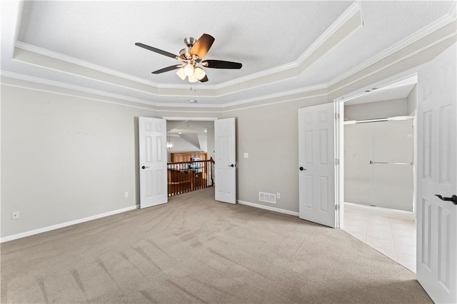 1103 N 2nd St E, Louisburg, KS 66053 - unfurnished bedroom with a tray ceiling, carpet, crown molding, and a ceiling fan