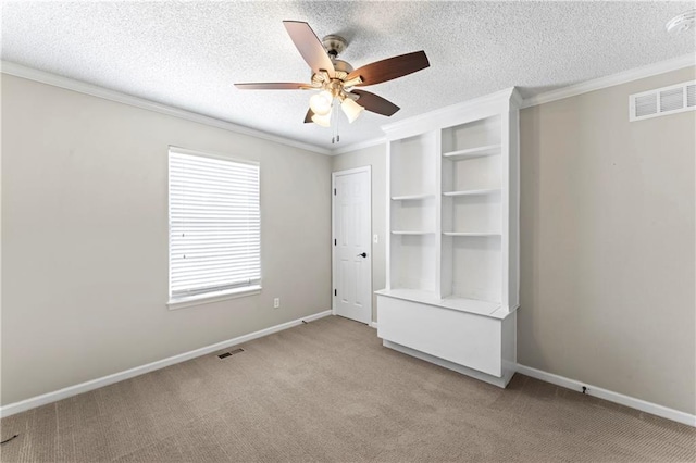 1103 N 2nd St E, Louisburg, KS 66053 - unfurnished bedroom with light colored carpet, crown molding, a textured ceiling, and ceiling fan
