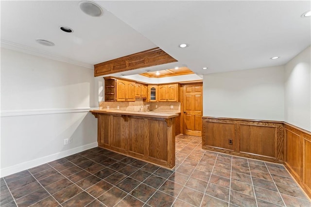 1103 N 2nd St E, Louisburg, KS 66053 - kitchen featuring a peninsula, a kitchen bar, recessed lighting, ornamental molding, and brown cabinets