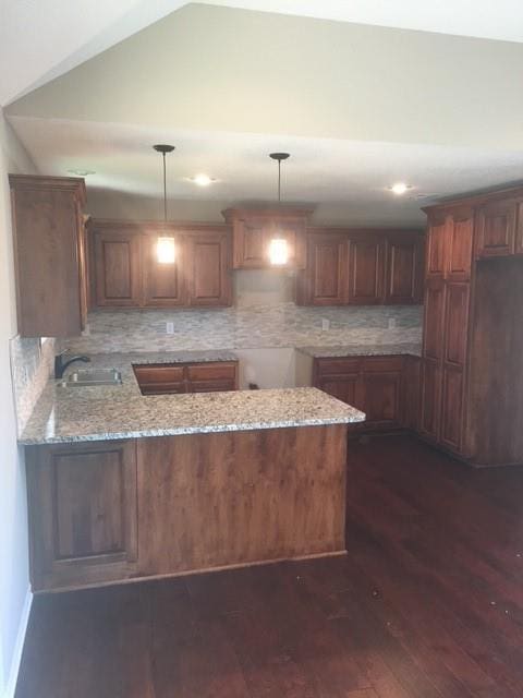 3812 SW Mcdanial Ave, Blue Springs, MO 64015 - kitchen with a peninsula, light stone countertops, dark wood finished floors, backsplash, and recessed lighting