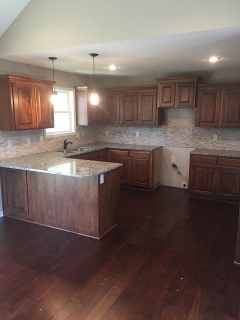 3812 SW Mcdanial Ave, Blue Springs, MO 64015 - kitchen with a peninsula, light stone counters, tasteful backsplash, dark wood-style floors, and recessed lighting