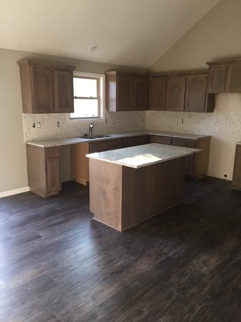 3812 SW Mcdanial Ave, Blue Springs, MO 64015 - kitchen featuring a kitchen island, tasteful backsplash, dark wood-style flooring, and lofted ceiling