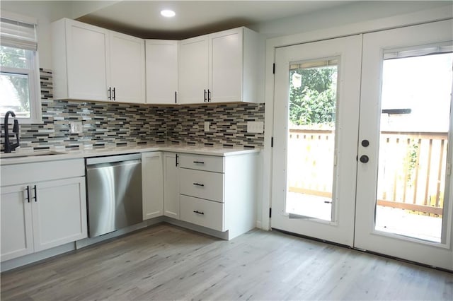 5032 E 8th St, Kansas City, MO 64124 - kitchen featuring dishwasher, light countertops, decorative backsplash, and white cabinetry