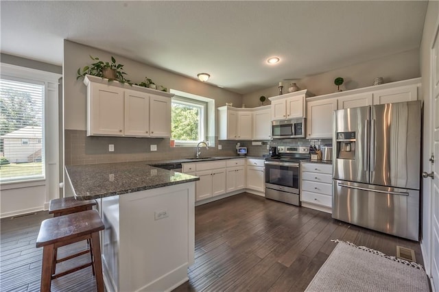 23317 W 52nd Ter, Shawnee, KS 66226 - kitchen with appliances with stainless steel finishes, white cabinetry, a peninsula, and dark wood-style flooring