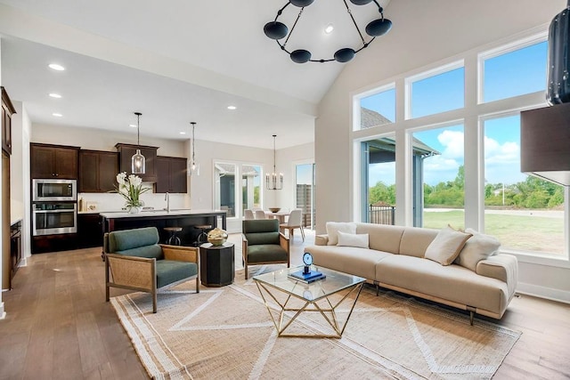 16567 W 170th St, Olathe, KS 66062 - living area featuring a chandelier, healthy amount of natural light, light wood-style floors, recessed lighting, and a high ceiling