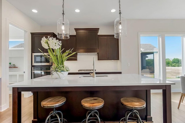 16567 W 170th St, Olathe, KS 66062 - kitchen featuring stainless steel appliances, dark brown cabinets, pendant lighting, recessed lighting, and light countertops
