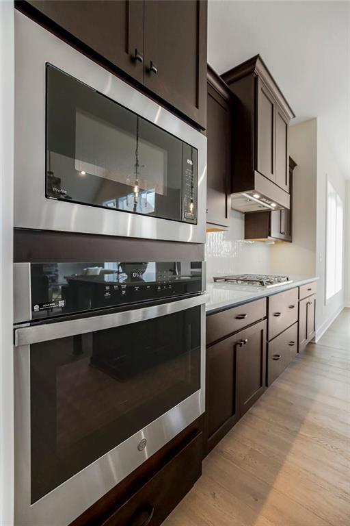 16567 W 170th St, Olathe, KS 66062 - kitchen featuring stainless steel appliances, light wood-style flooring, dark brown cabinets, and light countertops
