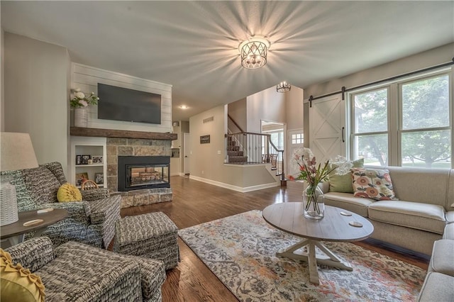 11508 Hauser St, Overland Park, KS 66210 - living room featuring stairs, wood finished floors, a stone fireplace, and a barn door