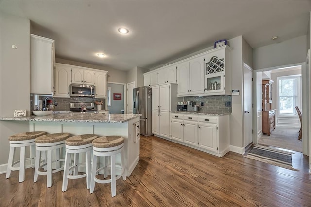 11508 Hauser St, Overland Park, KS 66210 - kitchen featuring stainless steel appliances, a peninsula, backsplash, white cabinetry, and recessed lighting