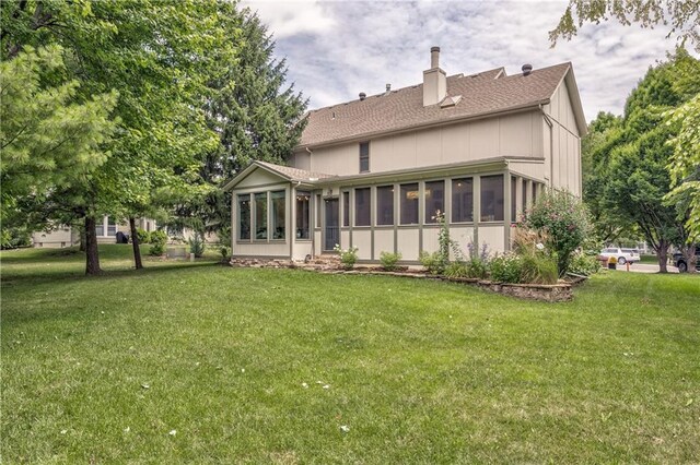 11508 Hauser St, Overland Park, KS 66210 - back of property featuring a sunroom, a chimney, a lawn, and a shingled roof