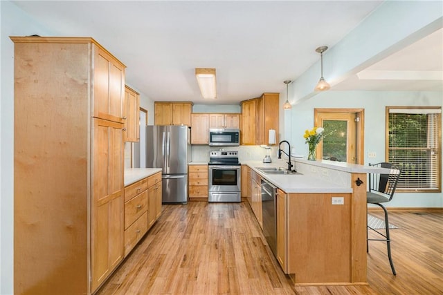 7608 N Serene Ave, Kansas City, MO 64152 - kitchen with appliances with stainless steel finishes, a peninsula, light wood-type flooring, a kitchen breakfast bar, and light countertops