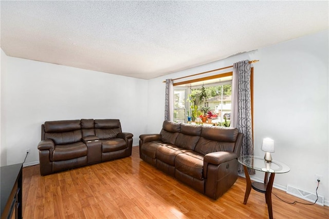 7608 N Serene Ave, Kansas City, MO 64152 - living area with a textured ceiling and light wood-type flooring