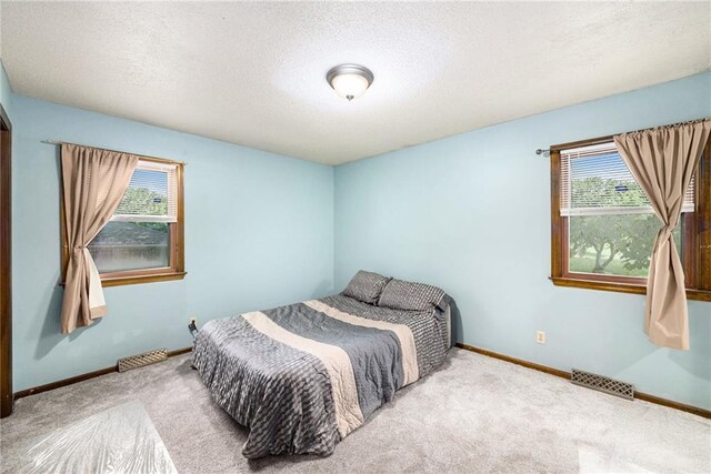 7608 N Serene Ave, Kansas City, MO 64152 - carpeted bedroom with multiple windows and a textured ceiling