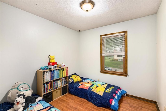 7608 N Serene Ave, Kansas City, MO 64152 - bedroom with wood finished floors and a textured ceiling