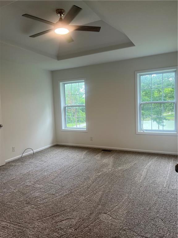 36987 W 63rd St, Camden, MO 64017 - empty room featuring a tray ceiling, a ceiling fan, and carpet